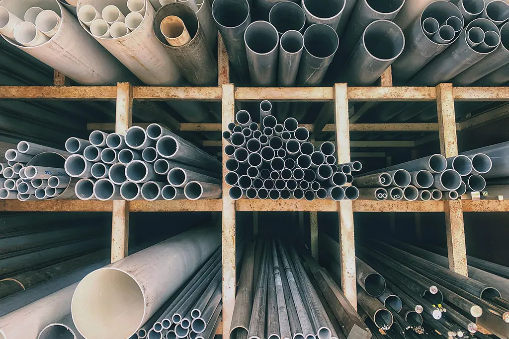 Various sizes oc PVC piple on shelves in a plumbing supply warehouse
